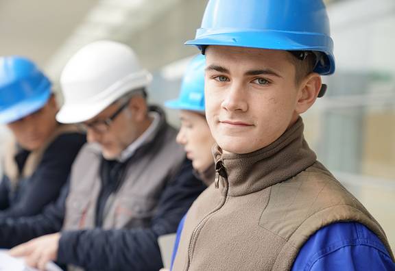 Jugendlicher mit Helm ist auf dem Bau