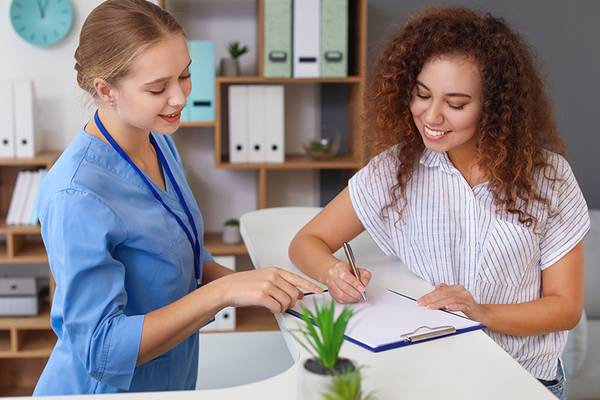 Zahnmedizinische Fachangestellte berät Patientin