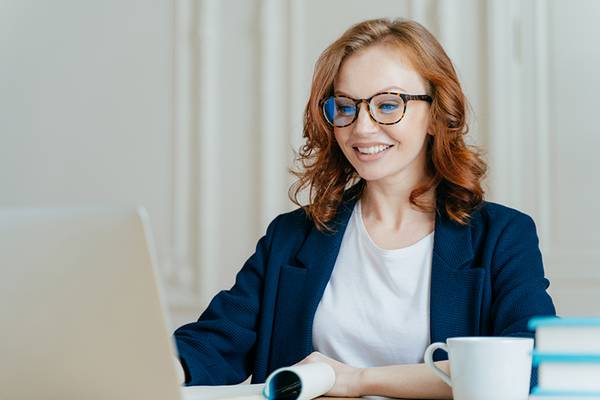 Lehrerin sitzt am Laptop