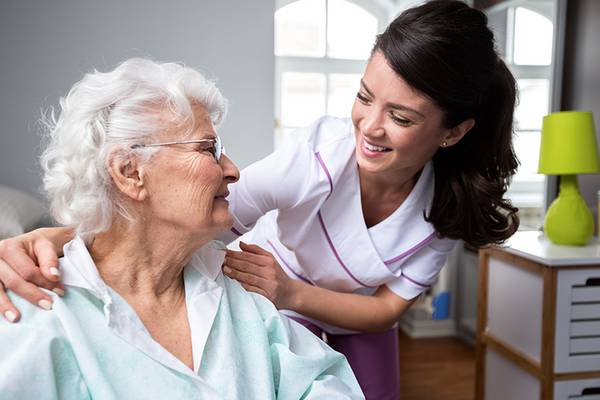 Krankenschwester und Patientin im Rollstuhl