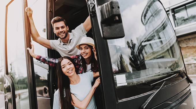 fröhliche Jugendliche stehen im Bus