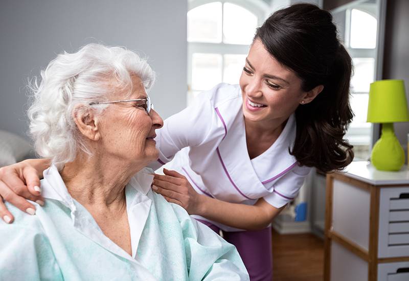 Krankenschwester und Patientin im Rollstuhl